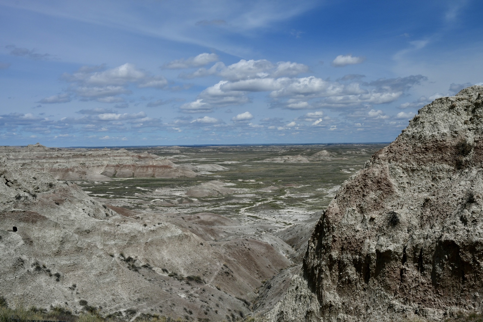 rot-weiße Felsberge, grüne Ebene, blauer Himmel: Badlands National Park