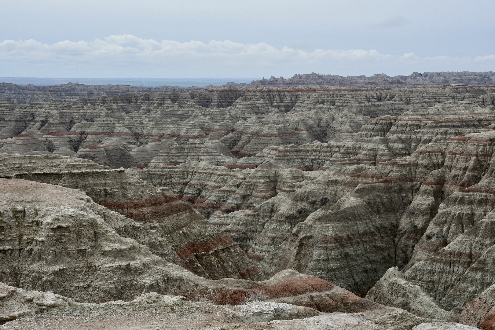 So weit das Auge reicht reihen sich kegelförmige gestreifte Felsen zu einem Gebirge aneinander im Badlands National Park