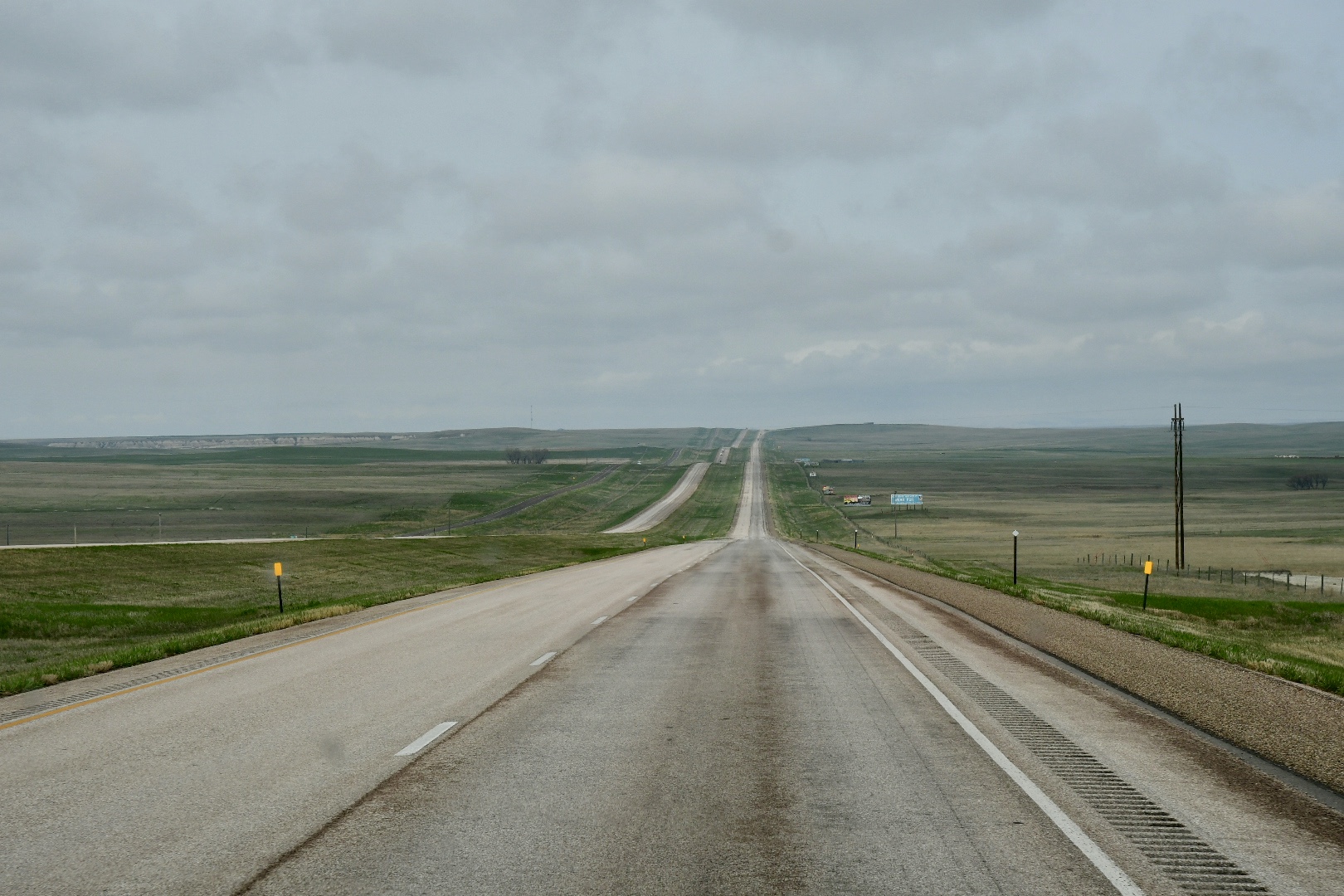 Schnurgerade führt ein vierspuriger Highway mit breitem Grünstreifen in der Mitte durch die gewellte Landschaft der Great Plains